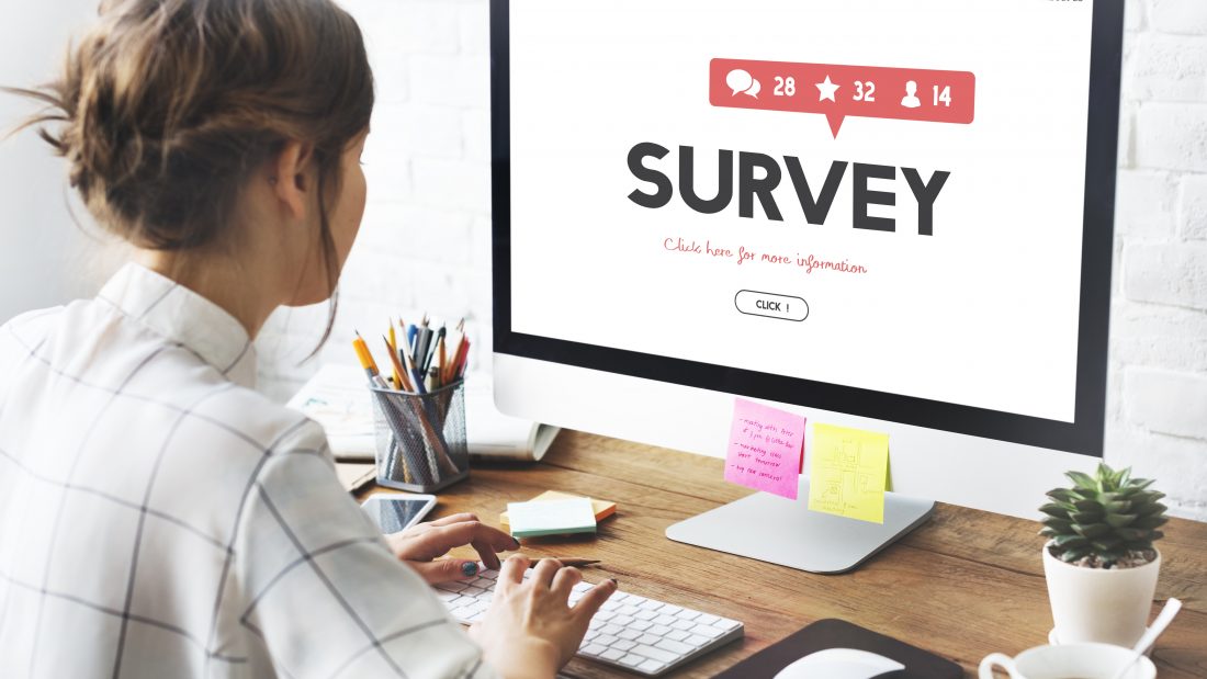 Lady sitting at a computer completing an online survey