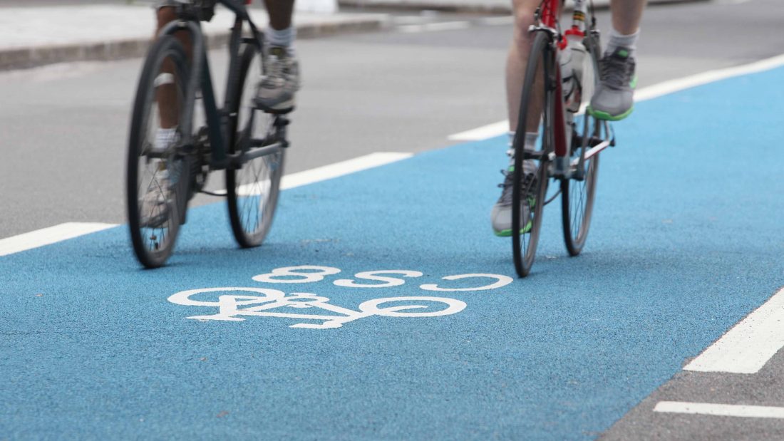 Photograph of a cycle superhighway and two cyclists demonstrating highway and access design