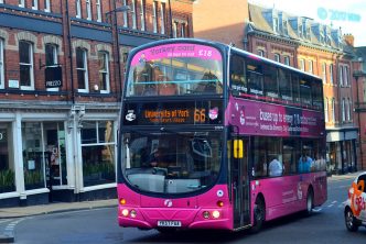A photograph of a pink bus travelling to University of York