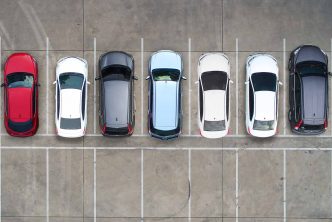 Photograph from up high showing a row of cars in a car park